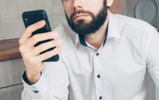 Person sitting quietly at home holding a phone, representing doomscrolling and mental health awareness
